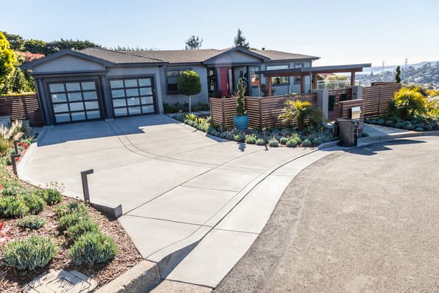 New Concrete residential driveway extending to a private road with new concrete curbs